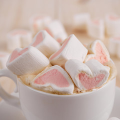 Pink sweet marshmallow hearts in a cup on wooden background. Valentine's day background, close-up