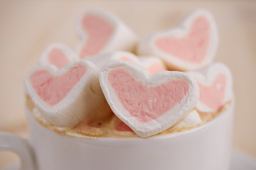 Pink sweet marshmallow hearts in a cup on wooden background. Valentine's day background, close-up