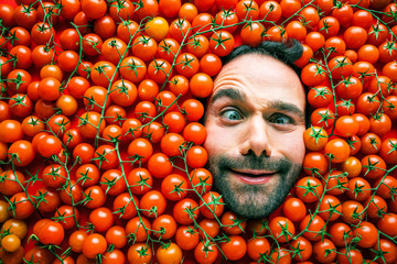Mann mit Tomaten , Konzept für lebensmittelindustrie. Gesicht von lachenden mann in Tomaten flache.