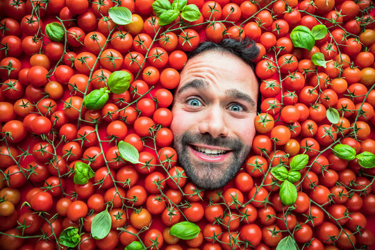 Mann mit Tomaten , Konzept für lebensmittelindustrie. Gesicht von lachenden mann in Tomaten flache.
