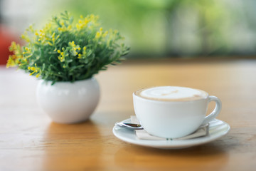 Coffee latte  in the white cup put on wooden table in the coffee cafe shop