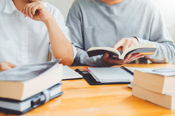 High school or college students studying and reading together in library