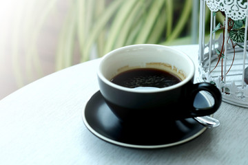 Well mixed black hot black coffee in black coffee cup on wood table served in a restaurant in a coffee break time, popular drink for meeting place and party time, value added design for better sales