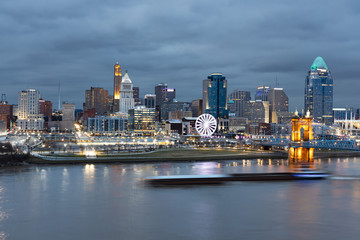Obraz premium View of Cincinnati Skyline with a Barge Zipping Through the Ohio River