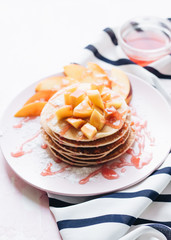 Stack of delicious homemade pancakes with sauce and sliced apple