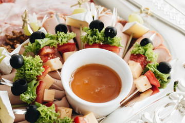Set of skewer canapes and sauce on plate 