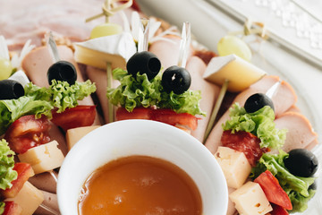 Set of skewer canapes and sauce on plate 