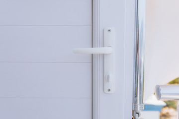 Plastic white vinyl door handle on the white vinyl door