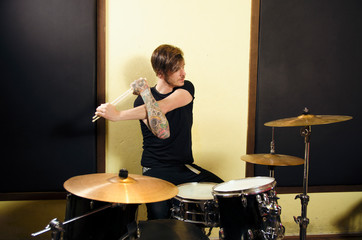 Drummer stretching with drum sticks before rehearsal  