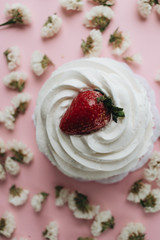 Fresh dessert with whisked cream and strawberry and flowers on table