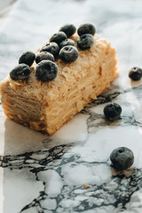Piece of delicious cake with blueberries on marble table, sweet dessert 