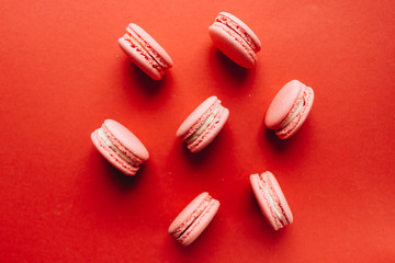Composition of delicious pink macaroons on red table sweet dessert