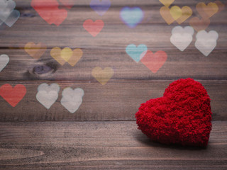 red cushion heart shape on wood background