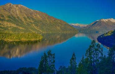 Naklejka na ściany i meble tranquilo lago rodeado por montañas con bosques