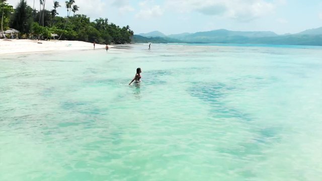 Aerial Circling: People on Stunning Tropical Beach with Crystal Clear Water