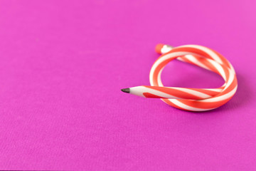Flexible pencil . Isolated on purple background. Bending pencil.