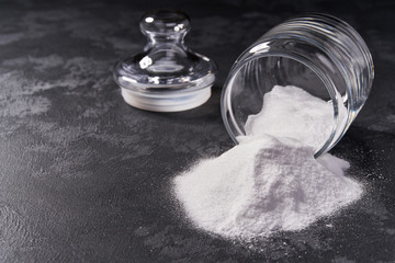 Jar of baking soda on a black background.