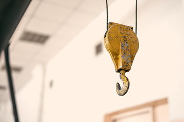 Yellow crane hook inside a factory building abstract background. © Dmitriy