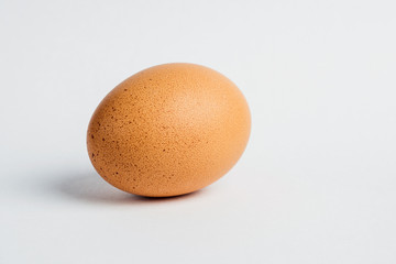 Close-up of fresh egg on white background. Selective focus.