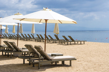Empty beach chairs and umbrellas on a beach of Sanur in Bali, Indonesia
