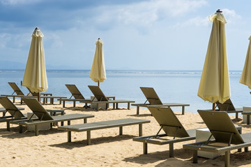 Empty beach chairs and umbrellas on a beach of Sanur in Bali, Indonesia