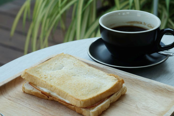 Ham cheese sandwich on wood tray and space for write wording, easy delicious food served with coffee or tea in coffee shop or office, suitable for new working life that need more time to work