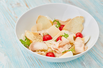 salad with chicken and vegetables on wooden background