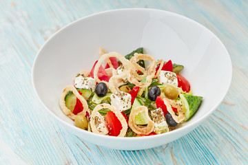 fresh salad in white bowl on blue wooden table