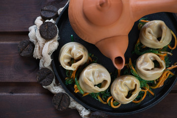 Above view of steamed asian dumplings with tea on a rustic wooden background, close-up