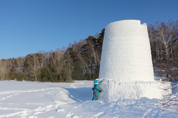 Woman standing by snow fortress, Novosibirsk, Russia