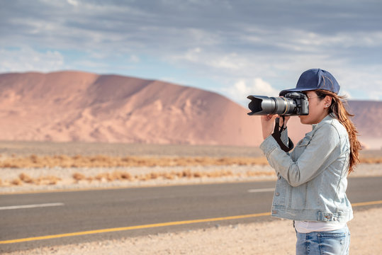 Woman photographer taking photo in the desert