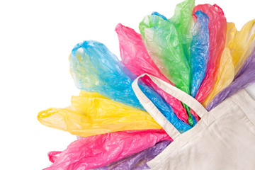 Many single use plastic bags in one eco natural reusable shopping bag on white background. Zero waste, eco friendly, sustainability lifestyle, no plastic concept