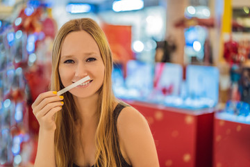 A woman with paper strips in her hands listens to the fragrance in the mall