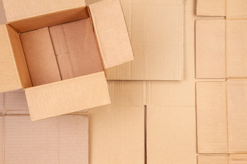 Open cardboard box on used corrugated striped cardboard boxes parts background