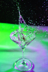 colorful cocktail in glass with splashes and lemon