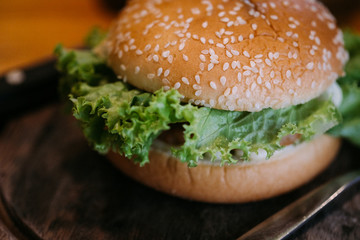 The burgers are on the appetizing wooden plate.