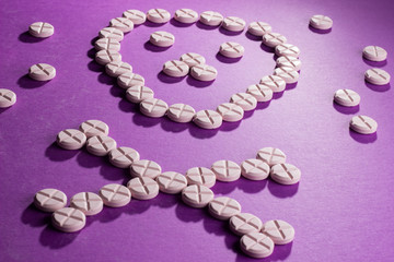 skull and bones lined with tablets lying on a purple background