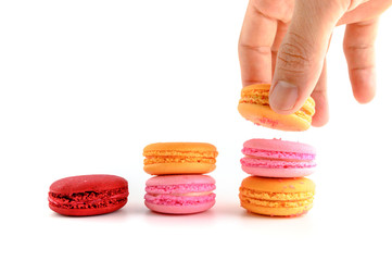 Male hand putting Macaroon stack growing up,Grow concept background, food concept on white background.