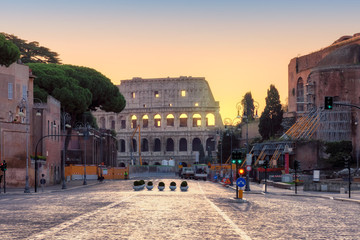 Fototapeta premium Roman street at dawn with a view of the Colosseum, Rome, Italy.
