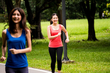 Portrait of young girl jogging in a park with her friend