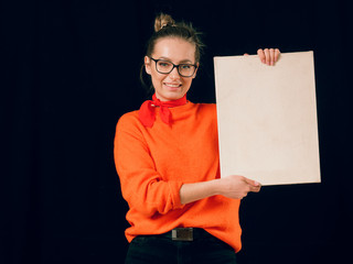 beautiful fashionable girl in red with a white poster on a black background.