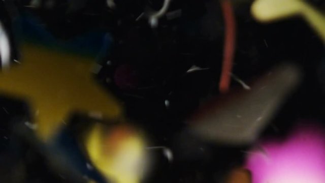 Confetti papers (stars, hearts, rose petals) fall on black background footage. 