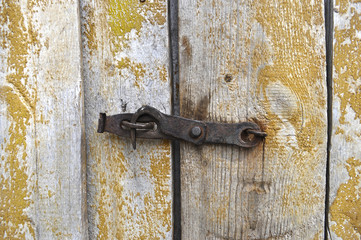 The door is closed on a rusty hook