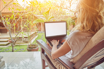 Girl using laptop on a home porch / terrace.