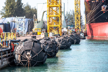 yokohama type of fender boating in floating installs in jetty of port against at marine vessel...