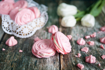 Pink raspberry meringues on a wooden background