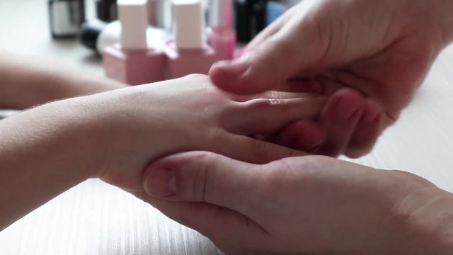 young mother helps her daughter paint her nails, processes nails and hands, hand massage