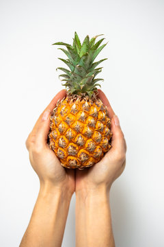 pineapple in hand close up on white background