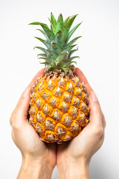 pineapple in hand close up on white background