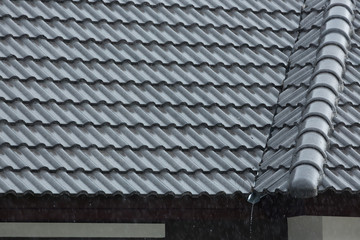 rain storm downpour on black roof tile of residential house